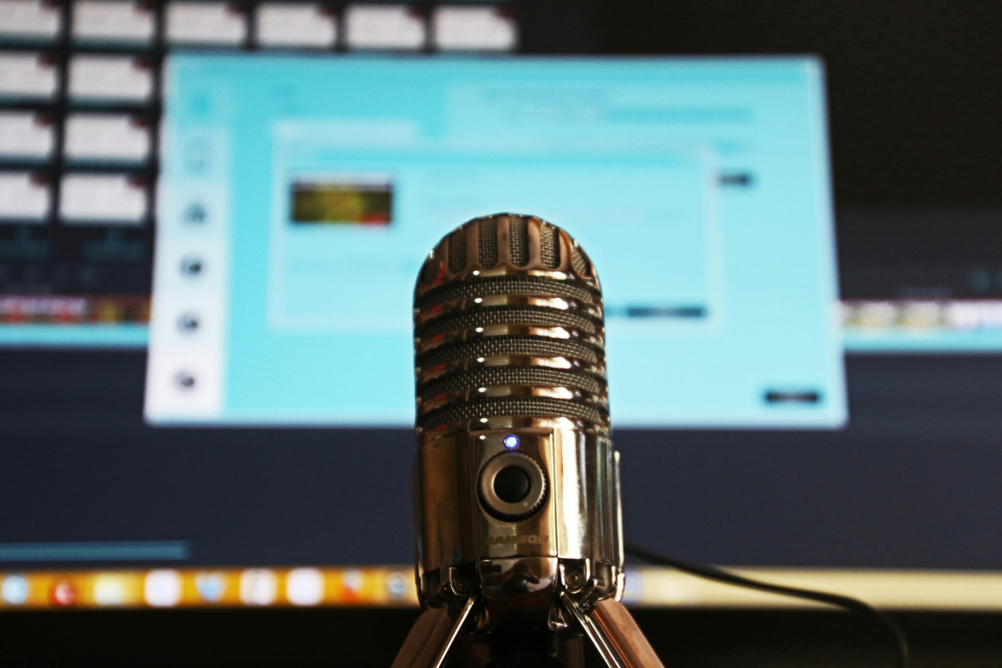 Photo of a microphone in front of a computer.